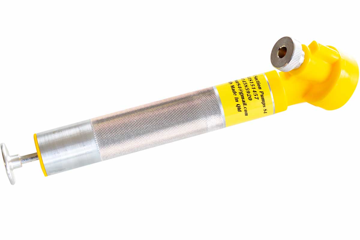 Hand-operated oil sampling pump with a metal barrel and yellow bottle holder